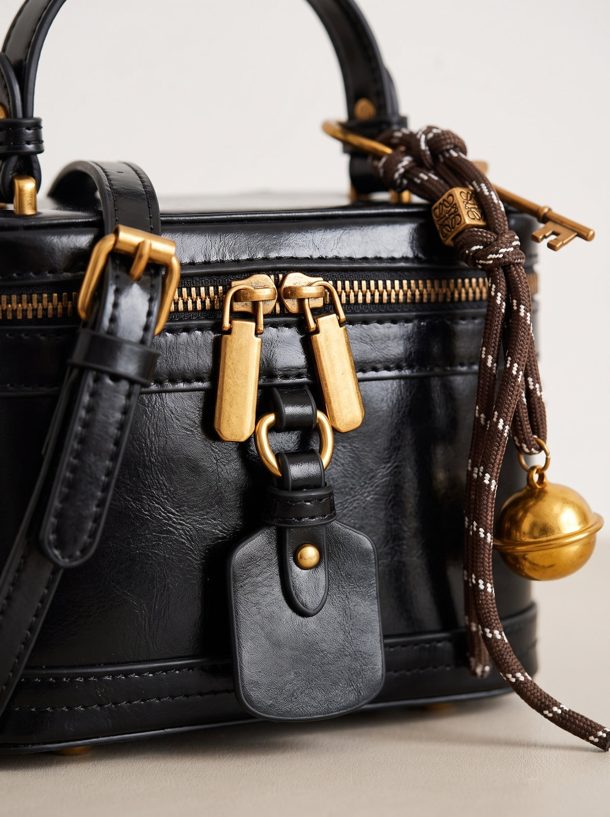 Detalle de la cremallera y los herrajes de latón del bolso neceser negro
