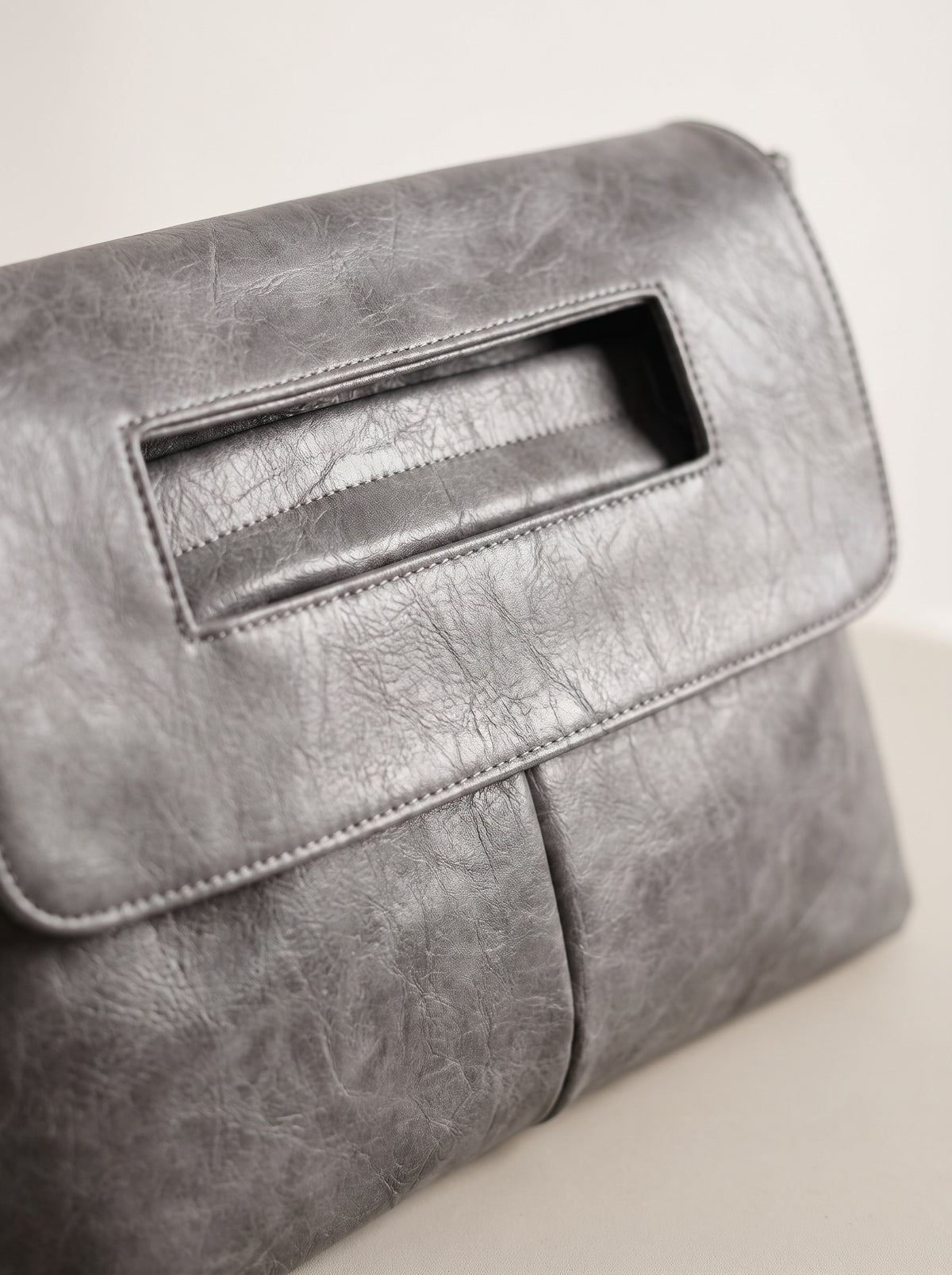 Detalle del asa recortada del clutch sobre gris